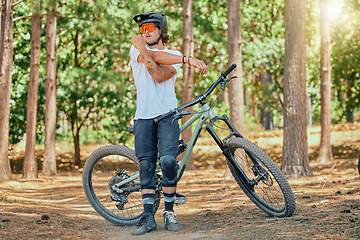 Image showing Mountain bike, man stretching in forest and outdoor, ready for cycling and extreme sports, helmet and goggles for safety. Fitness, warm up and riding in nature with bicycle, male athlete and training