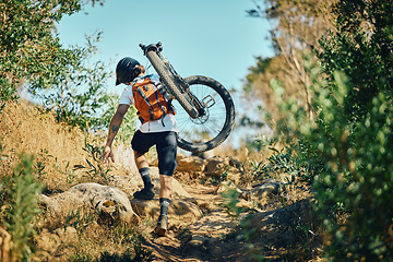 Image showing Man, back and carrying bicycle in nature, walking and traveling outdoor in woods. Sports, fitness and male cyclist or athlete carry mountain bike for exercise, training or workout for transportation.