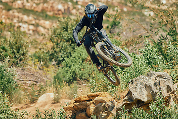 Image showing Action, sports and mountain bike with man jumping in nature for cycling, fitness and adventure. Adrenaline junkie, performance and stunt with athlete riding outdoors for energy, risk and training