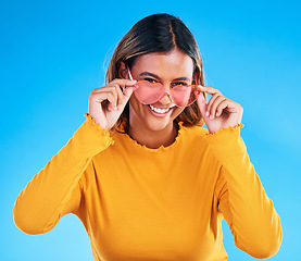 Image showing Fashion portrait, heart sunglasses and woman smile with casual spring clothes, designer brand glasses or outfit style. Gen z aesthetic, trendy face and young female model on blue background studio