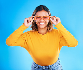 Image showing Fashion glasses, happy portrait and woman face with clothes, luxury designer brand or casual outfit style. Gen z summer aesthetic, trendy studio sunglasses and young female model on blue background