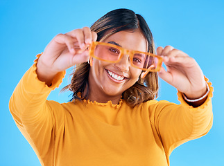 Image showing Fashion sunglasses, happy portrait and woman face with clothes, designer brand or casual outfit style. Gen z summer aesthetic, trendy studio glasses and young female model on blue background