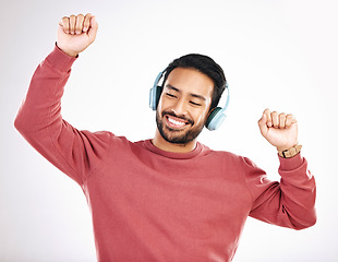 Image showing Headphones, happy and man dancing in a studio to music, playlist or album for entertainment. Happiness, dance and Indian male model moving to the radio or streaming a song by a white background.