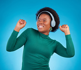 Image showing Dance, music and headphones with black woman in studio for streaming, audio and relax. Online radio, technology and listening with female isolated on blue background for hip hop and movement