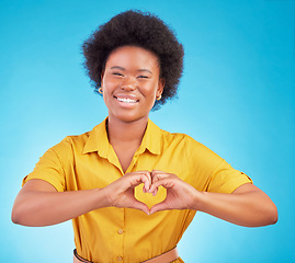 Image showing Heart hands, happy black woman and portrait in studio, blue background and backdrop for hope. Female model smile for finger shape, love emoji and thank you of support, peace and care sign of kindness