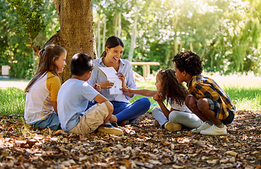 Image showing Books, reading or teacher with children in a park storytelling for learning development or growth. Smile, tree or happy educator with stories for education at a kids kindergarten school in nature