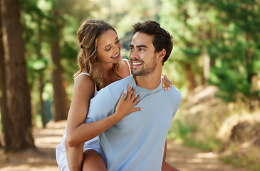 Image showing Couple in nature park, piggy back and happy relationship with love and trust, travel and adventure outside. Young people in forest, outdoor and happiness together with smile, commitment and hug