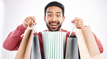 Image showing Wow, sale and portrait of man with shopping bag in studio, excited for discount or purchase on white background. Deal, face and indian guy with product from shop, mall or market while posing isolated