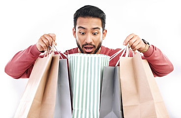 Image showing Sale, wow and shocked man with shopping bag in studio, excited for discount or purchase on white background. Deal, omg and indian guy with product from shop, mall or market while posing isolated