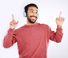 Image showing Headphones, smile and male dancing in a studio to music, playlist or album for entertainment. Happiness, dance and Indian man model moving to the radio or streaming a song by a white background.