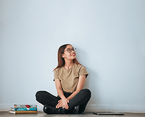 Image showing Textbook thinking, student woman and smile by a wall with school notes for learning with happiness. University, college and house with floor sitting of a happy person ready for studying with mockup