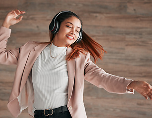 Image showing Dancing, excited and woman streaming to music with happiness or listening to audio online using headphones. Radio, wellness and happy female person dance isolated in a wooden wall background