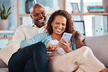 Image showing Couple, phone and laughing on sofa in home living room, social media comedy and having fun. Interracial, cellphone and funny black man and mature woman relax browsing online for comic joke or meme.