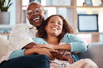 Image showing Couple, hug and laughing on sofa portrait in home living room, bonding and having fun. Interracial, love and funny black man and mature woman on couch embrace, relax and enjoying comedy together.