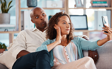 Image showing Couple, selfie and funny face on sofa in home living room, bonding or having fun. Interracial, self picture and black man and mature woman relax while taking photo for memory or social media together