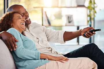 Image showing Couple, watching tv and laughing on sofa, hug in home living room and bonding. Interracial, television and funny black man and woman relax on couch streaming comedy movie, comic film or meme video.