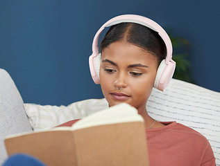 Image showing Woman, music headphones and reading book on home sofa to relax, study and for peace in living room. Face of young female student on couch to read for knowledge, education and language on couch