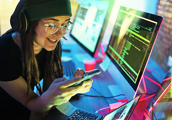 Image showing Woman, phone texting and computer programmer in home for streaming radio or podcast in neon. Hacker, music headphones or happy female coder with mobile for sound, audio or typing on dark web at night