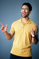 Image showing Karaoke, happy and a singing Asian man with a song isolated on a grey background in a studio. Smile, sing and a Japanese singer or artist enjoying, expressing and giving entertainment on a backdrop