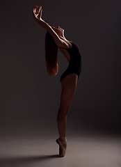 Image showing Ballet, woman and artist training, artistic and commitment with girl against a dark studio background. Female performer, lady and ballerina with creativity, happiness and practice for performance