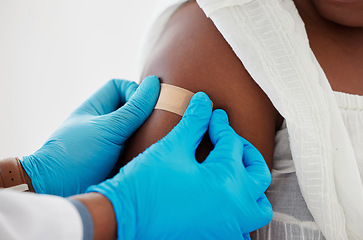 Image showing Vaccination, plaster and doctor helping patient with injection or medical vaccine in hospital. Consultation, appointment and hands closeup of healthcare worker putting arm bandage on woman in clinic