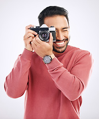 Image showing Photography, happy and man with a camera in a studio for creativity or art photoshoot job. Happiness, smile and Indian male photographer taking pictures for paparazzi or the media by white background