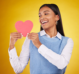 Image showing Happy, paper and heart with woman in studio for love, support and romance. Valentines day, kindness and date with female and holding symbol on yellow background for health, happiness and hope