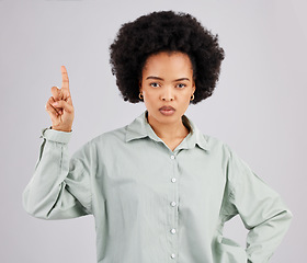 Image showing Mad, pointing and portrait of black woman in studio for product placement, promotion and announcement mockup. Idea, space and show with female on gray background for disappointed, annoyed or serious