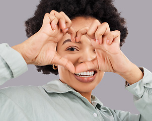 Image showing Heart, eye and hands with portrait of black woman in studio for happiness, support and emoji. Peace, focus and shape with female holding symbol on gray background for hope, kindness and trust