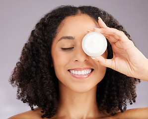 Image showing Happy woman, face and smile for skincare moisturizer or beauty against a gray studio background. Female smiling with teeth holding cosmetic product for healthy skin, self care or facial treatment