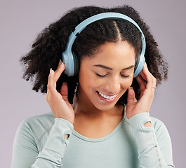 Image showing Woman, headphones and smile listening to music in joy against a gray studio background. Happy and fun female model smiling and relaxing in happiness with headset for audio track, sound or podcast
