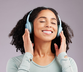 Image showing Happy woman, headphones and smile listening to music in joy against a gray studio background. Fun and calm female smiling and relaxing in happiness with headset for audio track, sound or podcast