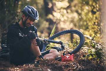 Image showing Sports man, injury and first aid outdoor while cycling on mountain bike in nature with leg or knee pain. Athlete person on ground in forest for fitness exercise, training or workout accident or fall