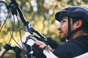 Image showing Forest, fitness and cyclist carrying bicycle in nature with helmet, exercise adventure trail and healthy mindset. Cycling, woods and man with mountain bike in trees for workout, motivation or energy.