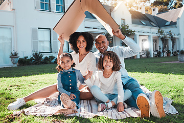 Image showing Cardboard roof, portrait and family relax on the lawn of new home, property or real estate, happy and excited. House, gesture and face of kids with parents relax on grass, proud and mortgage success