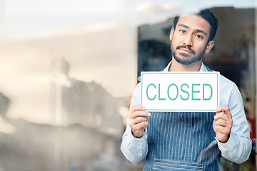 Image showing Asian man, small business and closed sign for out of service in coffee shop or restaurant closing. Portrait of male entrepreneur, manager or waiter holding billboard or poster sorry for close in cafe