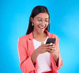 Image showing Happy business woman, phone and social media in surprise for deal, discount or online sale against a blue studio background. Excited creative female on smartphone smiling for communication or startup