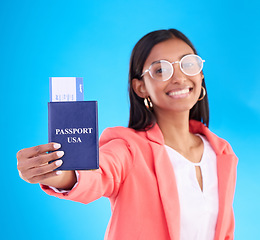 Image showing Passport, ticket and portrait of woman in travel, flight or USA documents against a blue studio background. Happy female business traveler smile holding international boarding pass or booking trip