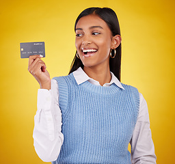 Image showing Credit card, excited and Indian woman on yellow background for bank, investment and payment in studio. Banking mockup, finance and happy girl with plastic for budget, commerce and promotion purchase