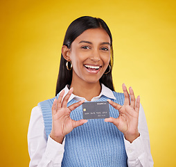 Image showing Credit card, smile and portrait of Indian woman on yellow background for bank, investment and payment in studio. Banking mockup, finance and girl with product for budget, commerce and sale purchase