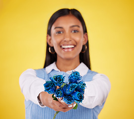 Image showing Portrait, love and roses with a woman on a yellow background in studio for valentines day. Face, blue flowers or smile with a happy young female holding a plant for romance or anniversary celebration