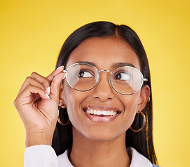 Image showing Happy, smile and woman with glasses in a studio for optical health, wellness and awareness. Happiness, optometry and Indian female model with spectacles for eye care isolated by a yellow background.