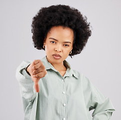 Image showing Portrait, thumbs down and black woman serious in studio isolated on a white background. Hand gesture, person or female with dislike emoji, negative opinion or no, rejection or failure, vote or wrong.