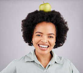 Image showing Apple on head, balance and portrait of black woman in studio for nutrition, wellness and healthy snack. Food, diet and girl smile with fruit for detox, vitamins and weight loss on white background