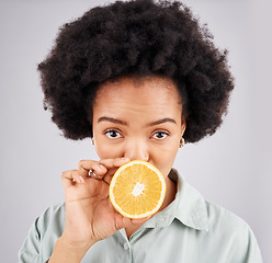 Image showing Portrait, orange and black woman fruit in studio isolated on a white background. Food face, nutritionist and serious person or female with vitamin c, nutrition or healthy diet, citrus or vegan detox.