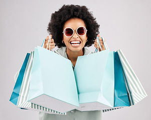 Image showing Portrait, shopping bags and black woman laughing with sunglasses in studio isolated on a white background. Sales deals, fashion and happiness of rich, funny and wealthy person with retail products.