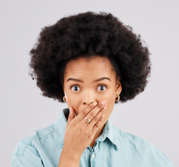 Image showing Portrait, hand and mouth with a surprised woman in studio on a gray background feeling shocked by gossip. Face, wow or afro and a young female hearing news with an omg or wtf expression of disbelief