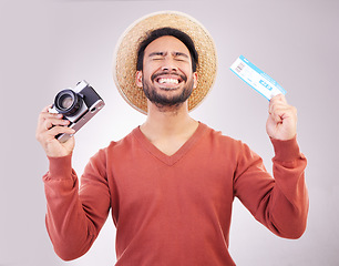 Image showing Ticket, camera and excited man in studio with paperwork for holiday, adventure and fun hat on white background. Smile, travel and happy person with boarding pass for vacation, journey and happiness.