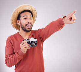 Image showing Travel, camera and surprise, man pointing on holiday, adventure and mockup on white background. Smile, point and photographer in studio showing gesture of shock on vacation with discovery on journey.