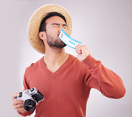Image showing Excited man, ticket and visa with camera, travel and paperwork for holiday adventure and on white background. Smile, travel and happy person kissing boarding pass for vacation, journey and happiness.